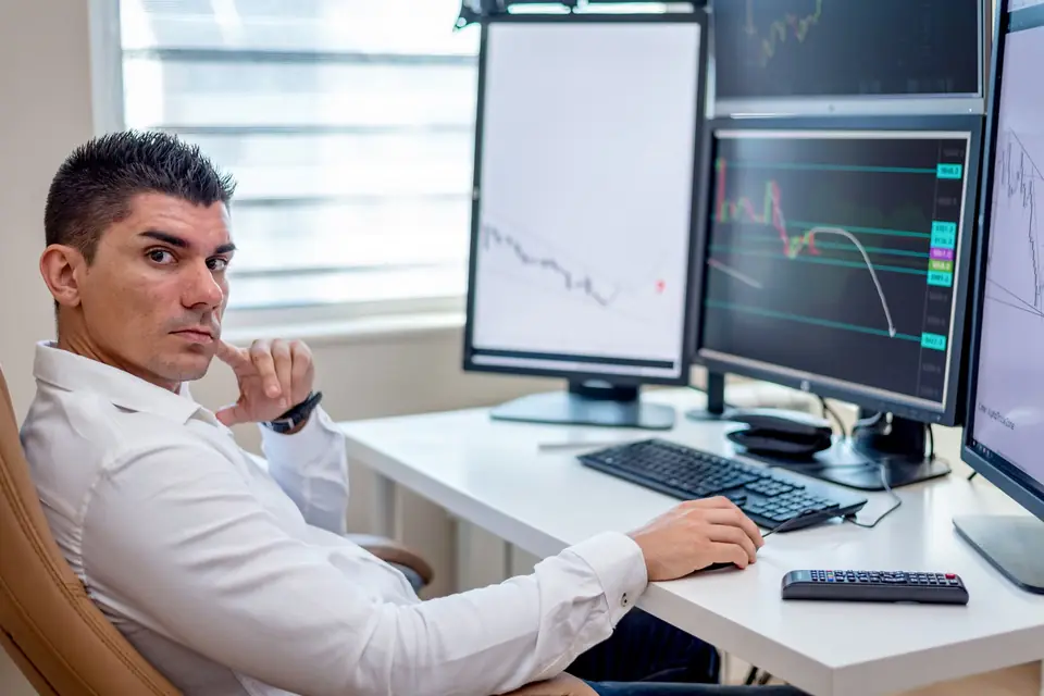 Analyst watching monitoring dashboards across several screens