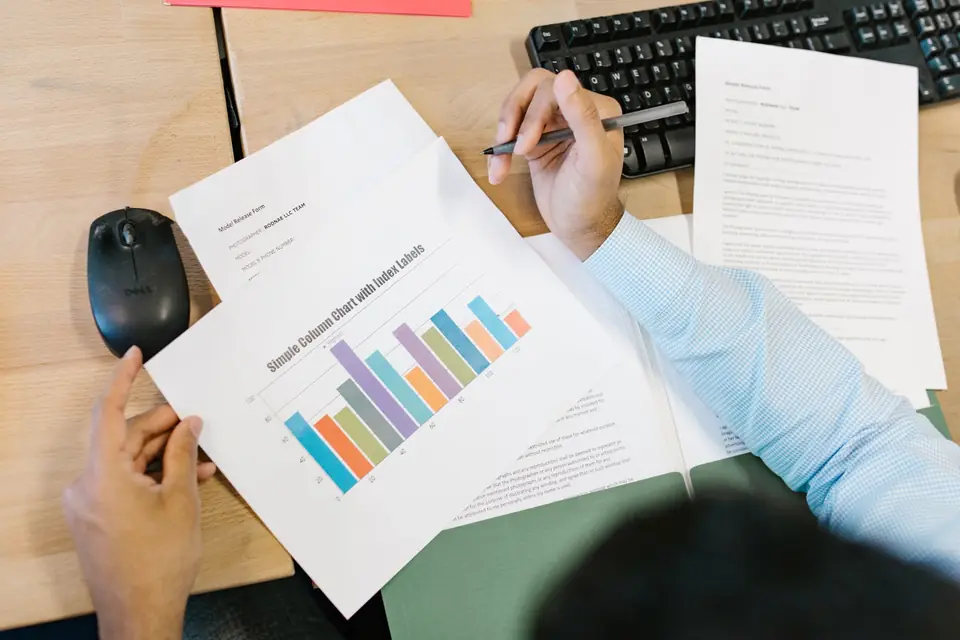 Reviewing a printed performance chart at a desk, scoring how content is received